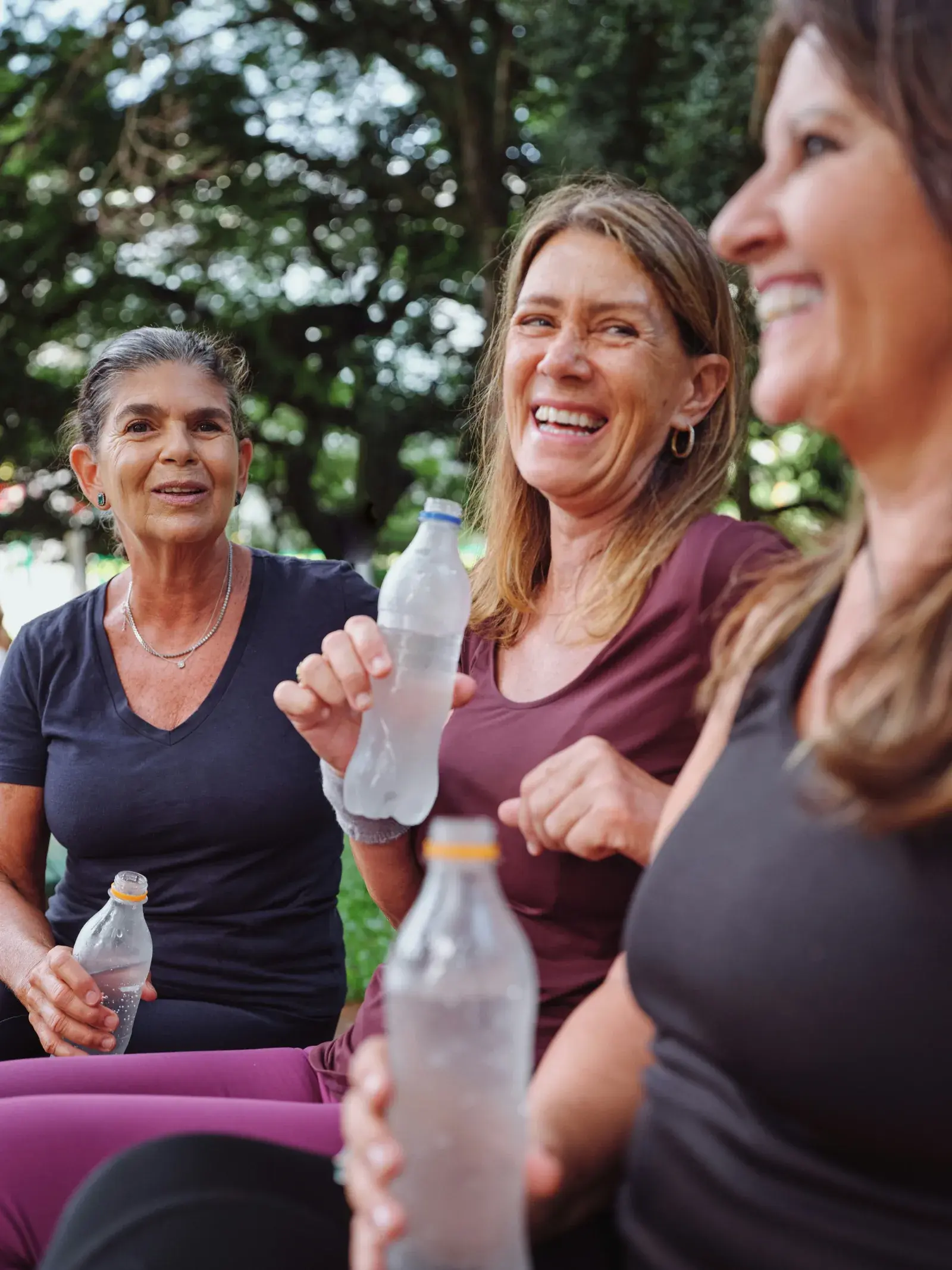 Three smiling women drinking water